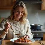 Femme en pull chaud servant un boeuf carotte dans la cuisine
