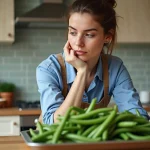 Femme examinant des haricots verts bio dans la cuisine